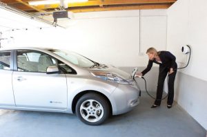 Nissan Leaf plugged into Chargemaster homecharge wallmounted unit in garage