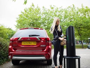 Red Mitsubishi Outlander PHEV electric vehicle charging at a public Chargemaster fast post