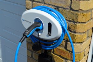Blue cabled Chargemaster tethered white homecharge unit mounted on house wall