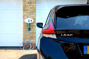 2018 Nissan Leaf charging at a white coloured Chargemaster tethered wall mounted home charge unit